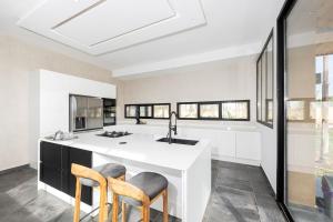 a kitchen with a white island with two chairs at Prestige home in Et Tnine Oudaya