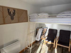 a room with two bunk beds and two chairs at STUDIO LES JONQUILLES in Les Angles