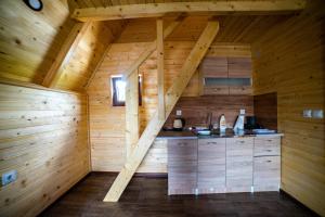 an attic kitchen in a log cabin with wooden walls at Una Relax in Vajagići