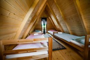 two bunk beds in a wooden cabin with a window at Una Relax in Vajagići