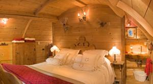 a bedroom with a bed in a log cabin at Hôtel Les Chalets de Philippe avec Jacuzzis Privatifs in Chamonix