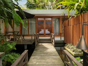 una casa con passerella in legno che conduce a un patio di Wanasekar Resort a Beran-kidul