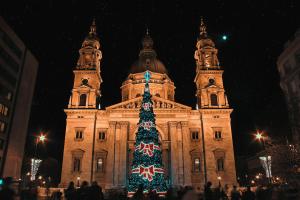 a large building with a christmas tree in front of it at Three Corners Downtown Hotel in Budapest