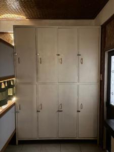 a row of white cabinets in a kitchen at Jungle Hostel in Puerto Princesa City