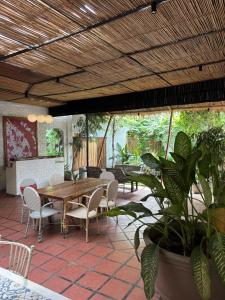 a patio with a wooden table and chairs and a plant at Jungle Hostel in Puerto Princesa City