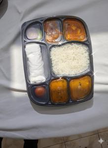 Hotel RS international Couple Friendly في نيودلهي: صينية طعام مع الرز والمكونات الأخرى