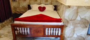 Una cama con una manta roja encima. en Nakshatrahomestay, en Vattavada