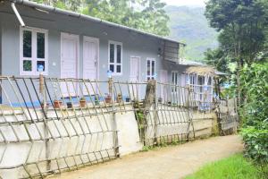 una casa con una valla delante en Nakshatrahomestay, en Vattavada