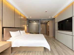 een slaapkamer met een groot bed en een flatscreen-tv bij Starway Hotel Shanghai Hongqiao National Exhibition and Convention Center Beiqing Road in Shanghai