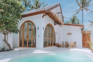 a villa with a swimming pool and a house at Lumora Boutique Villas in Gili Trawangan