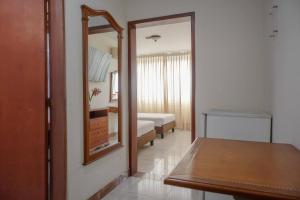 a room with a mirror and a bedroom with a bed at Hotel Faranda Bolivar Cucuta, a member of Radisson Individuals in Cúcuta