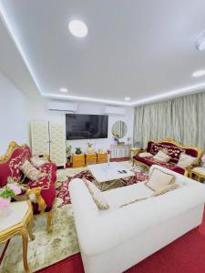 ein Wohnzimmer mit einem weißen Sofa und Stühlen in der Unterkunft modern private studio reteat , al manhal-7 in Abu Dhabi