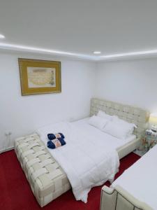 ein Schlafzimmer mit einem großen weißen Bett und einem Sofa in der Unterkunft modern private studio reteat , al manhal-7 in Abu Dhabi