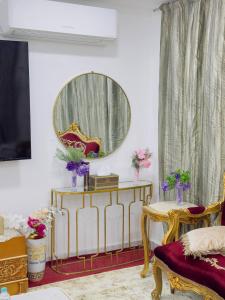 ein Wohnzimmer mit einem Spiegel und einem Stuhl in der Unterkunft modern private studio reteat , al manhal-7 in Abu Dhabi + 1 Foto