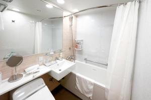 Un baño con lavabo, bañera y espejo. en Comfort Hotel Yokkaichi, en Yokkaichi 49 fotos más