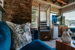 a living room with a blue couch and a brick wall at Słoneczny dom nad Jeziorem Bystrzyckim in Zagórze Śląskie