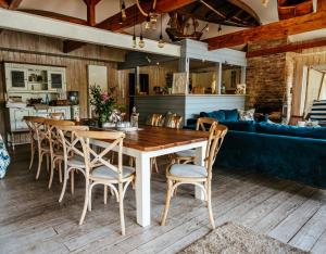a dining room with a wooden table and chairs at Słoneczny dom nad Jeziorem Bystrzyckim in Zagórze Śląskie