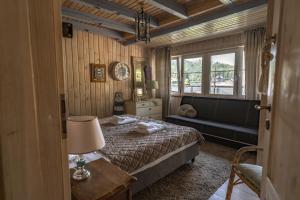 a bedroom with a bed and a couch and a window at Słoneczny dom nad Jeziorem Bystrzyckim in Zagórze Śląskie