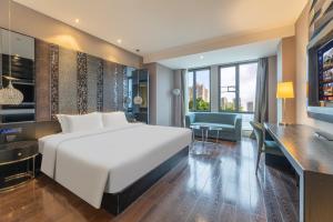 Un dormitorio con una gran cama blanca y un escritorio. en Guangzhou Baiyun Airport Orange Crystal Hotel, en Huadu 51 fotos más