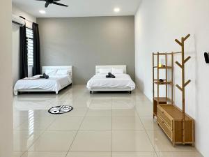 zwei Betten in einem Zimmer mit weißen Wänden in der Unterkunft 4BR Cozy Villa for 16 Pax Quiet Area & Spacious in Simpang Ampat