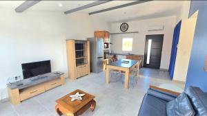 a living room with a table and a kitchen at Résidence La Clé des Champs in Clam