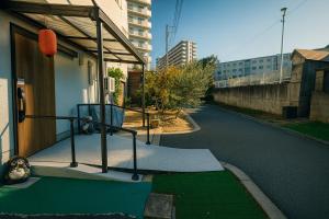 Barrier Free Guesthouse Support Included في أوساكا: شارع خالٍ مع سرير على جانب مبنى