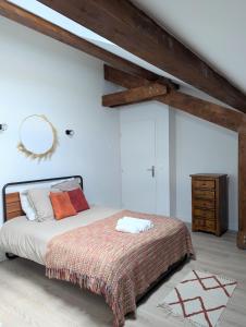 een slaapkamer met een bed en een houten plafond bij ERA - Optional parking in Romans-sur-Isère