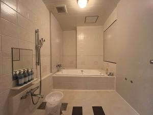 ein weißes Badezimmer mit Badewanne und Waschbecken in der Unterkunft SKY Windy Adult Only Love Hotel in Kitakyūshū