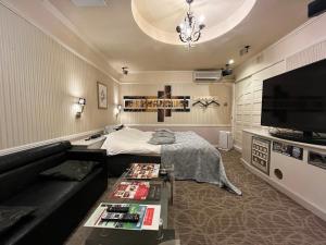 ein Wohnzimmer mit Sofa und Fernseher in der Unterkunft SKY Windy Adult Only Love Hotel in Kitakyūshū
