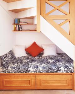 a bed in a small room under a staircase at Le refuge du prieuré - Les Gîtes de la Côte d'Amour in Batz-sur-Mer