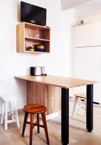 a wooden table in a kitchen with two stools at Le refuge du prieuré - Les Gîtes de la Côte d'Amour in Batz-sur-Mer