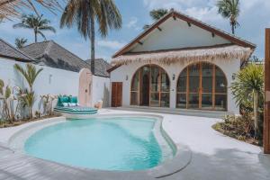 a swimming pool in front of a house at Lumora Boutique Villas in Gili Trawangan