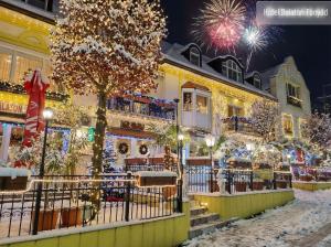 a building covered in christmas lights with fireworks at Hotel Balaton Fonyód in Fonyód
