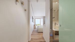 a hallway with white walls and a bathroom at Hotel Moré in Alcudia