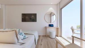 a living room with a white couch and a mirror at Hotel Moré in Alcudia