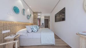 a bedroom with a bed with blue pillows at Hotel Moré in Alcudia +57 photos