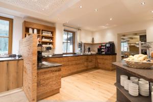 a large kitchen with wooden cabinets and a counter at Familienhotel Oberkarteis in Hüttschlag