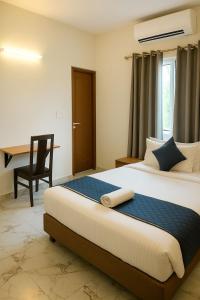 a bedroom with a bed with a desk and a chair at Hotel Stay Bliss Marathahalli in Bangalore +62 photos