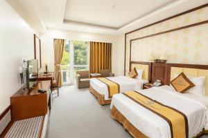 a hotel room with two beds and a television at Central Hotel in Móng Cái +54 photos