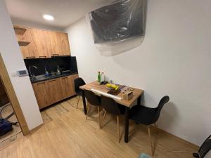 una pequeña cocina con mesa de madera y sillas en SkyLux Vlašić, en Šišava