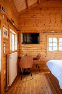 ein Schlafzimmer mit einem Bett und einem Tisch und einem Fernseher in der Unterkunft karion houses in Synikia Mesi Trikalon