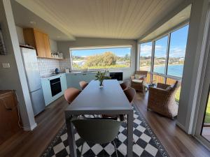 Beach Buoy Opossum Bay في South Arm: مطبخ وغرفة معيشة مع طاولة وكراسي