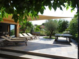 a patio with chairs and a ping pong table at Les Voiles in Pinarellu
