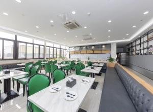een eetkamer met tafels en groene stoelen bij Starway Hotel Shanghai Hongqiao National Exhibition and Convention Center Beiqing Road in Shanghai