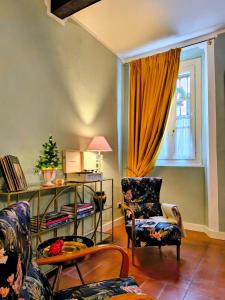 a living room with a chair and a window at Il Sonetto - Boutique Apartment Suite in Mantova