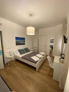 ein Schlafzimmer mit einem Bett, einem Tisch und einem Stuhl in der Unterkunft Holidays Rooms Via Colombo 32 in La Spezia + 4 Fotos