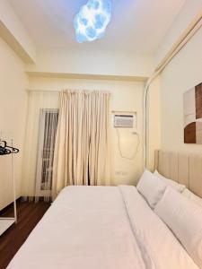 a bedroom with a bed and a window at Cloud Cinema by Kozy Mood near BGC in Manila