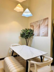 a dining room with a white table and two chairs at Cloud Cinema by Kozy Mood near BGC in Manila +9 photos