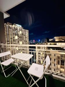 a table and chairs on a balcony with a city skyline at Cloud Cinema by Kozy Mood near BGC in Manila