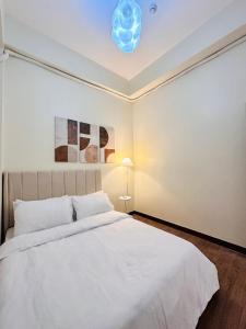 a bedroom with a white bed and a ceiling at Cloud Cinema by Kozy Mood near BGC in Manila
